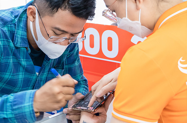 Khách hàng ký tên lên linh kiện của điện thoại